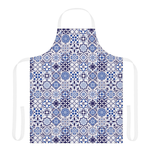 A white apron with a blue and navy geometric tile pattern, featuring a neck loop and waist ties, shown against a plain white background.