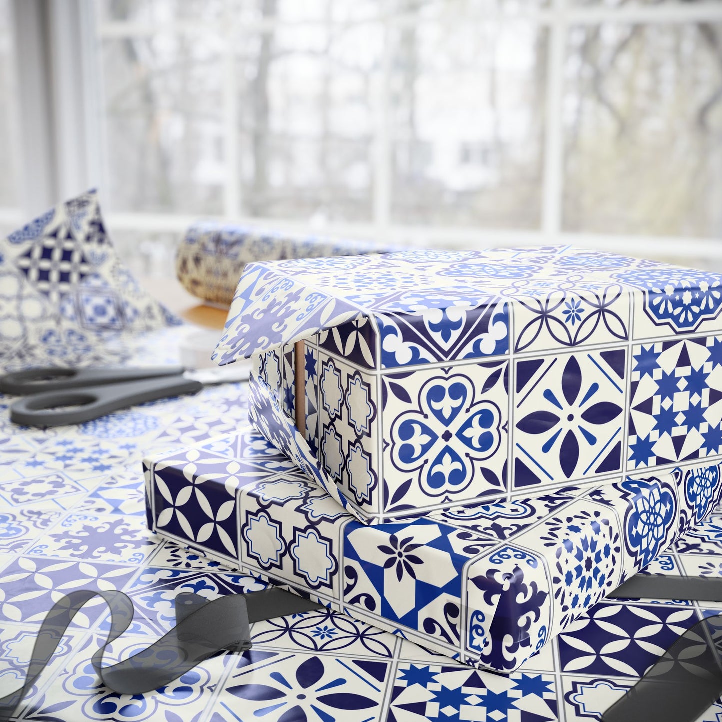 Stack of wrapped presents with blue and white azulejo pattern on a table.