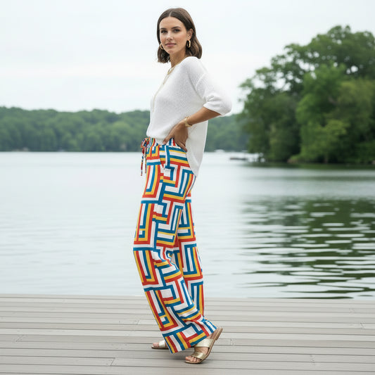 Colorful Wide-Leg Pants featuring a bold geometric maze pattern in red, blue, yellow, and white. High-waisted, comfortable palazzo style with a drawstring waist and pockets. Ideal for summer fashion, casual wear, resort wear, or retro/mod style looks. Bohemian, comfortable, vibrant trousers.