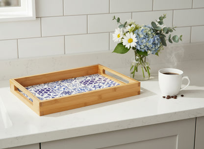 Bamboo tray with a blue and white Portuguese tile patterned on a white kitchen counter with flowers and coffee