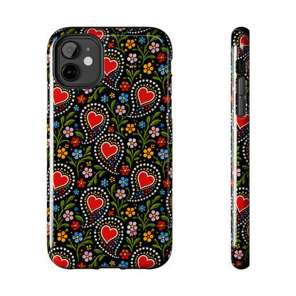 A phone case shown from the back and side on a plain white background. The case has a black base with a colorful folk-art style pattern featuring red hearts, green vines, and small multicolored flowers.