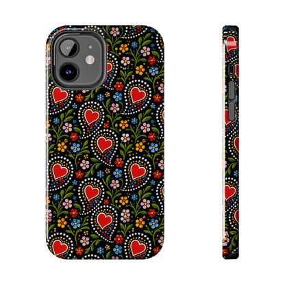 A phone case shown from the back and side on a plain white background. The case has a black base with a colorful folk-art style pattern featuring red hearts, green vines, and small multicolored flowers.