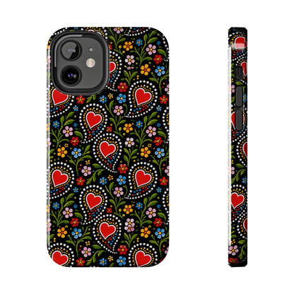 A phone case shown from the back and side on a plain white background. The case has a black base with a colorful folk-art style floral and heart pattern featuring red hearts, green leaves, and small multicolored flowers.