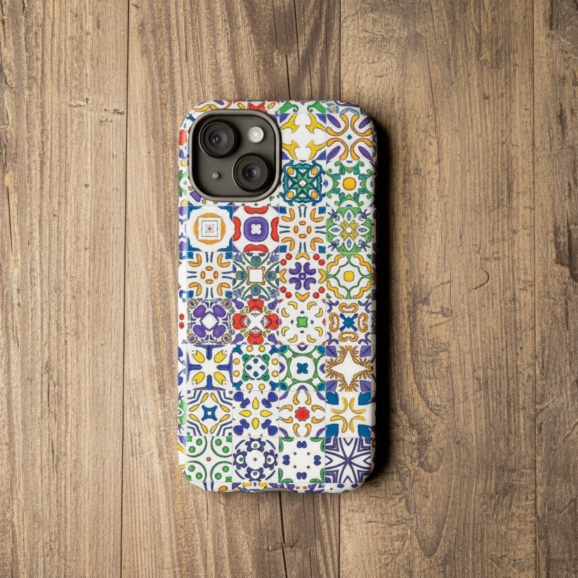 Colorful patterned phone case on a wooden surface with a camera and plant in the background