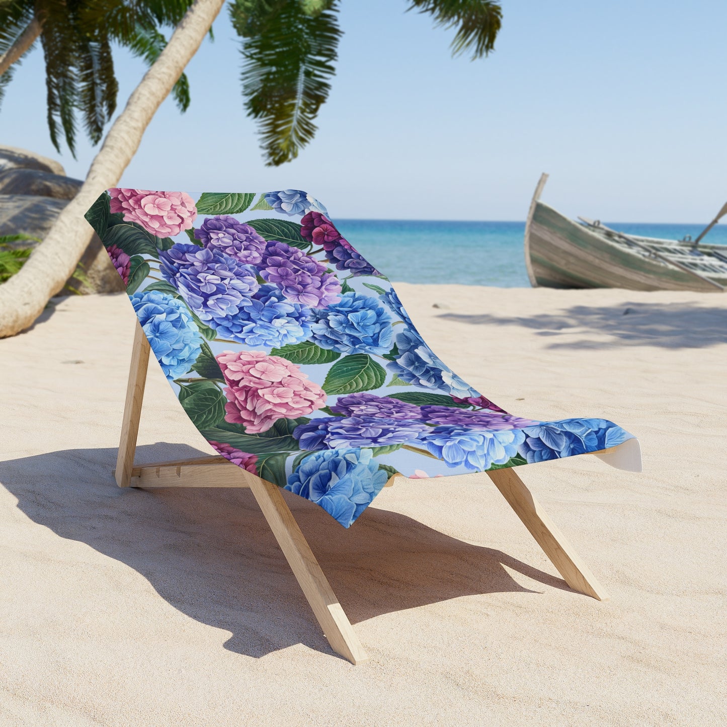 Floral-patterned beach towel draped over a wooden chair on a sandy beach with palm trees and ocean in the background.