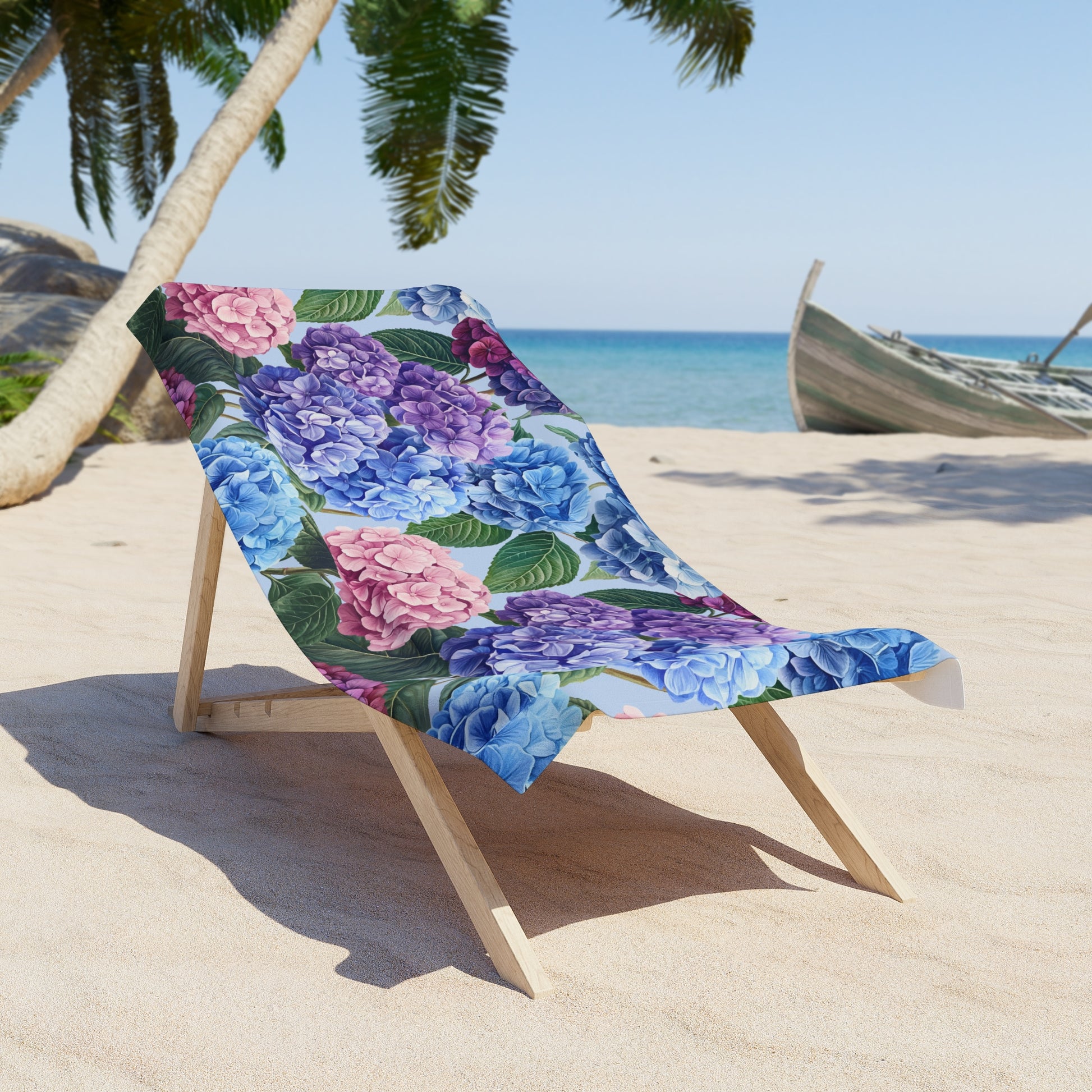 Floral-patterned beach towel draped over a wooden chair on a sandy beach with palm trees and ocean in the background.