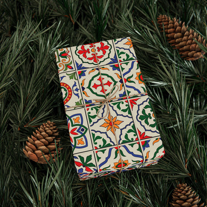 Decorative gift box with colorful portuguese tile pattern on a bed of pine needles and pine cones.
