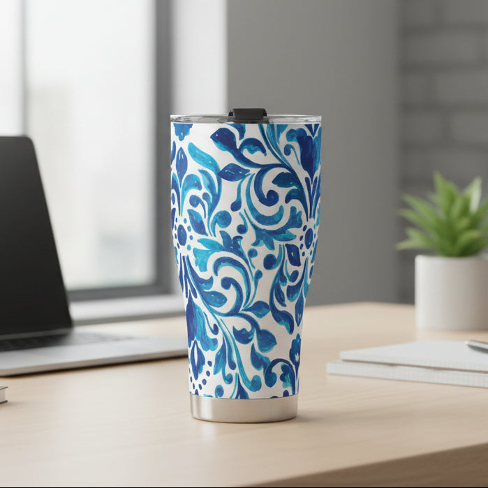 A stainless steel tumbler with a vibrant blue and white scroll pattern, featuring a secure lid.