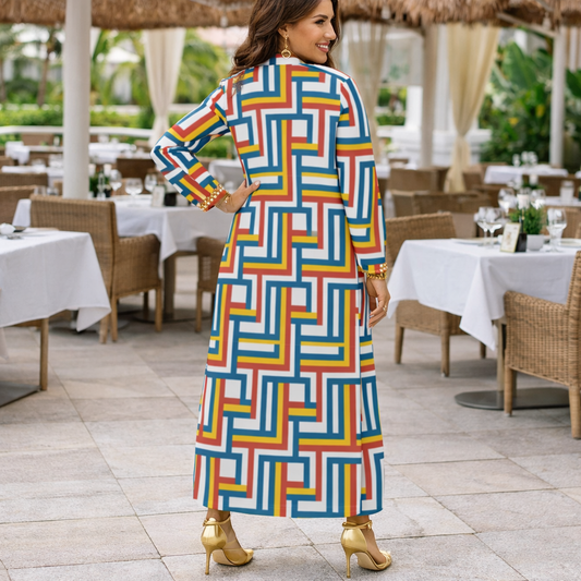 Woman in a colorful geometric dress standing in an outdoor dining area.