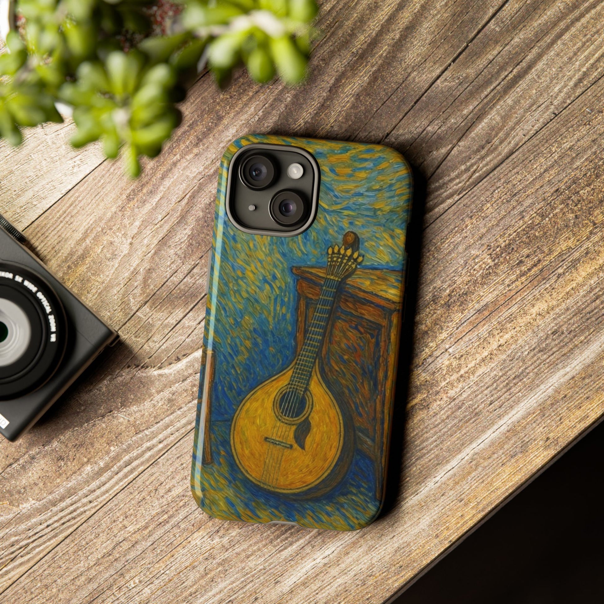 Phone case with mandolin design on a wooden surface next to a camera