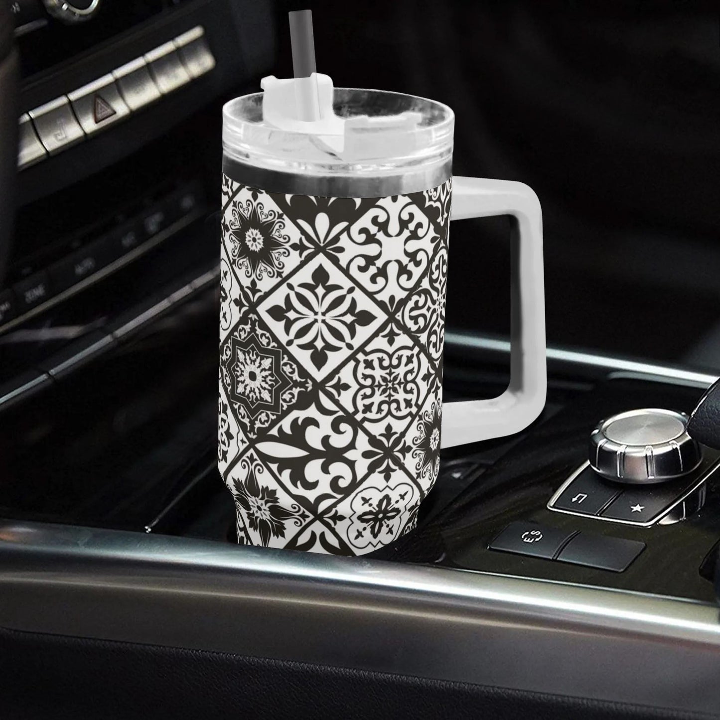 Black and white patterned tumbler with handle on a car dashboard