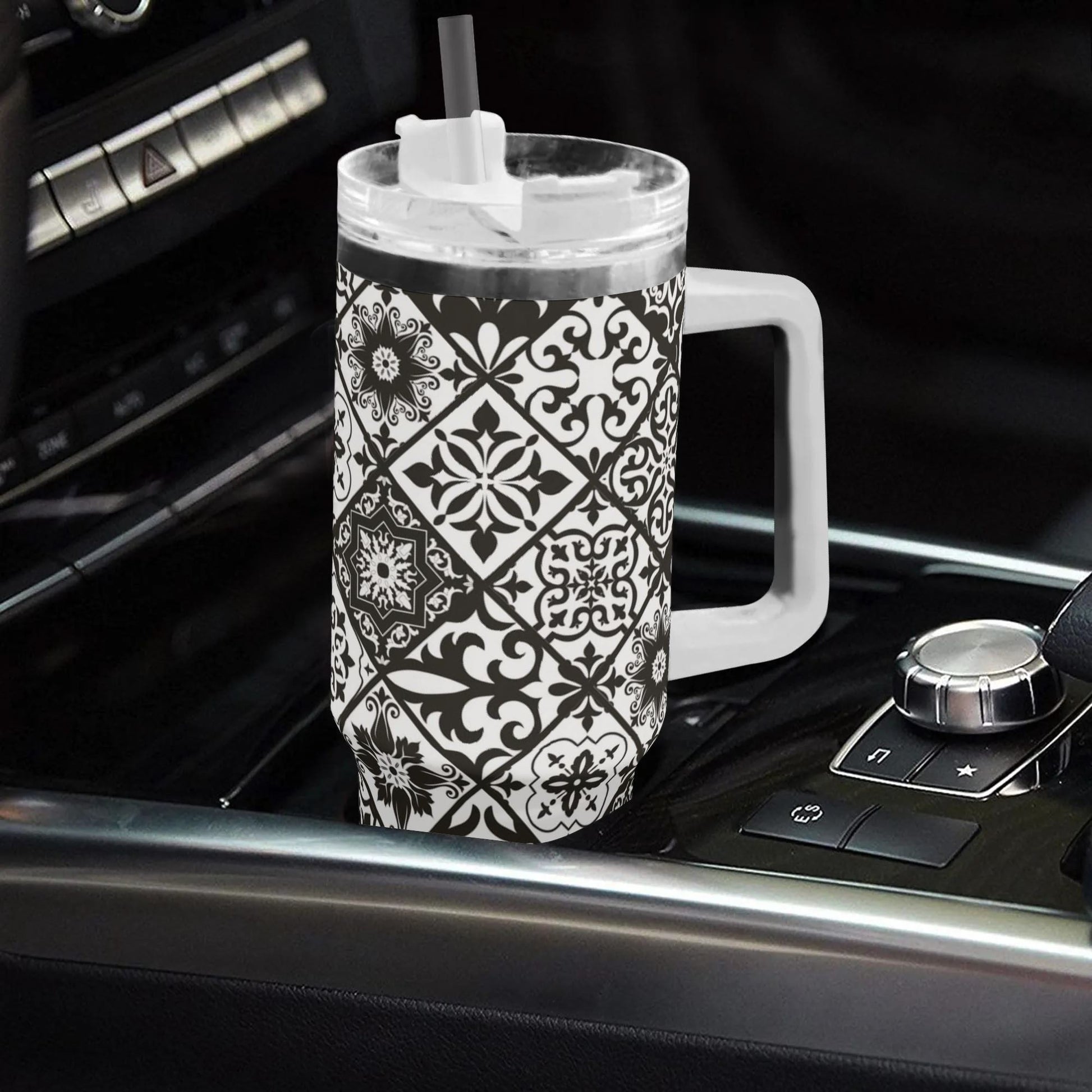 Black and white patterned tumbler with handle on a car dashboard