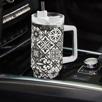 Black and white patterned tumbler with handle on a car dashboard