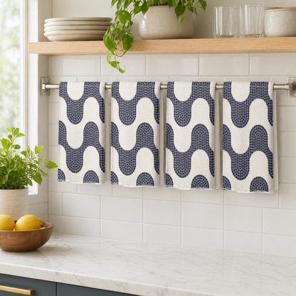 Kitchen towel with geometric pattern hanging on a rack against a tiled wall.