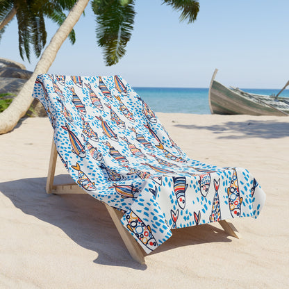 Colorful towel draped over a beach chair on a sandy beach with palm trees and ocean in the background.