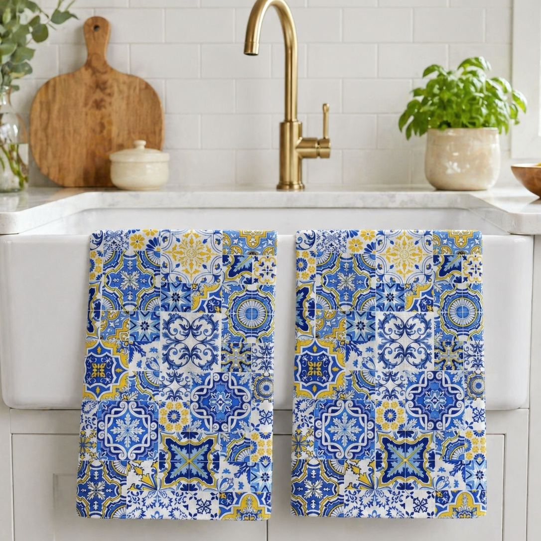 Two blue and yellow patterned towels hanging on a kitchen towel rack.