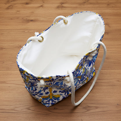 White drawstring bag with blue and yellow pattern on a wood background
