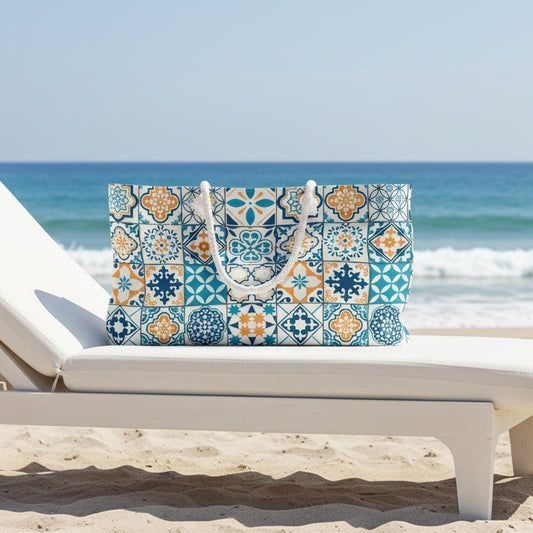 A tote bag featuring a colorful Mediterranean-style tile pattern in blue, teal, orange, and white, with two white rope handles, shown against a plain white background.