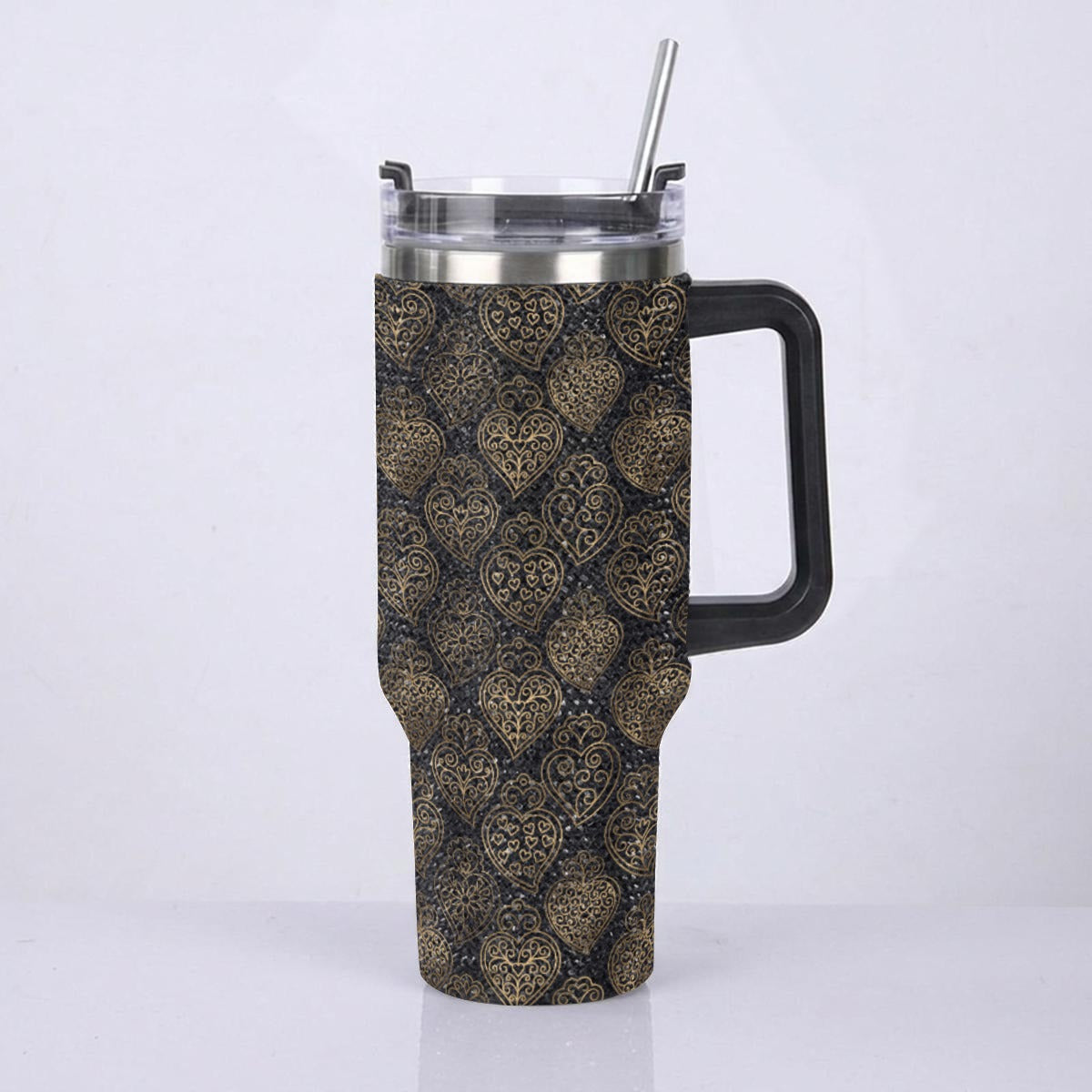 A handled travel tumbler with a black handle and a clear lid with a metal straw, featuring a dark brown and gold damask pattern wrap, shown against a plain white background.