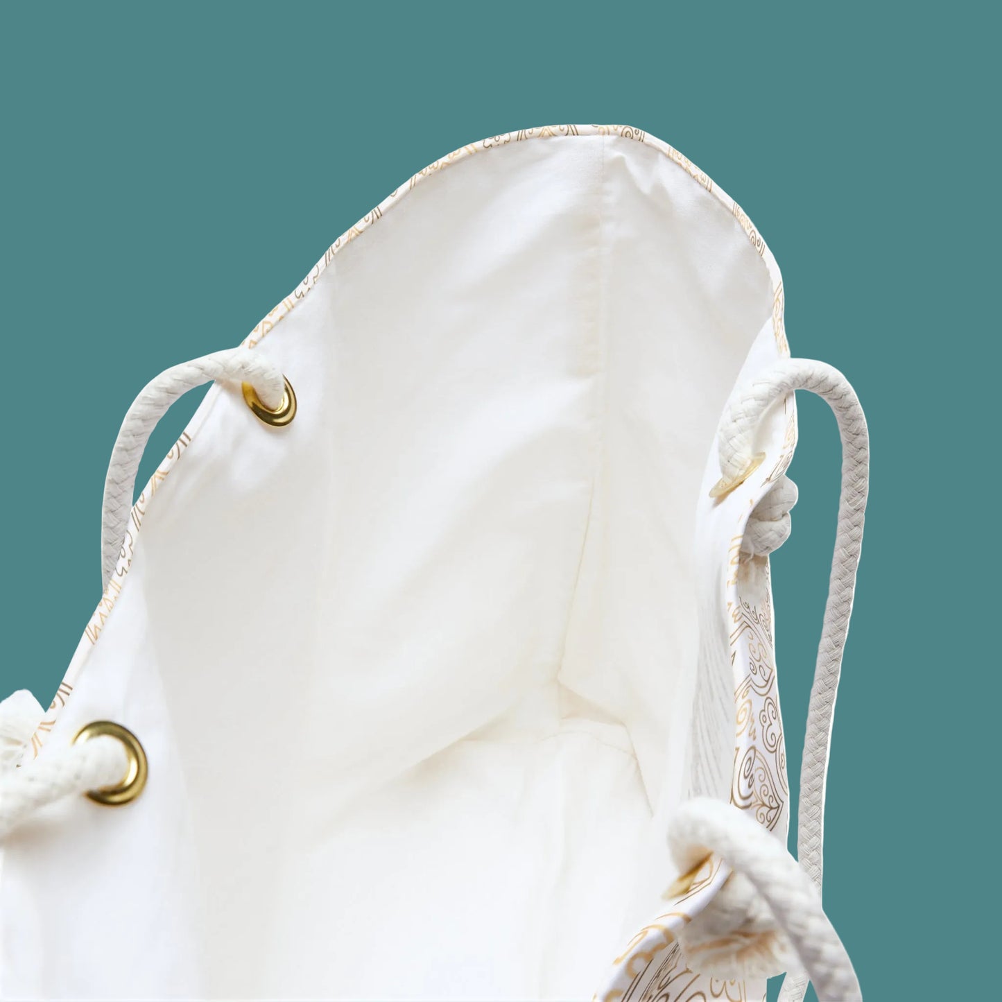 White drawstring bag with gold accents on a white background