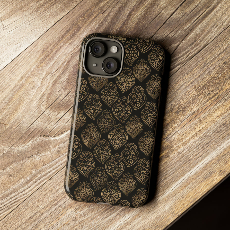 Phone case with heart pattern on a wooden surface next to a camera