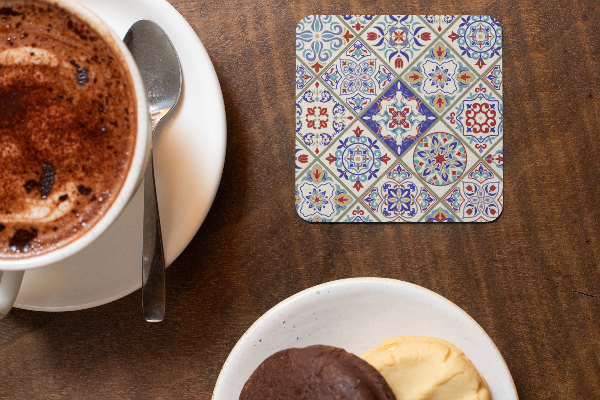 Cup of coffee with cookies on a wooden table, featuring a decorative coaster.
