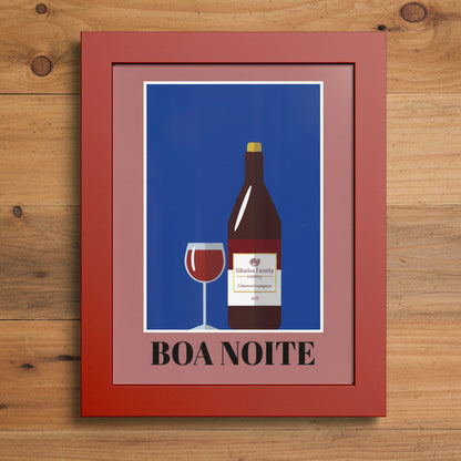 Framed wall art featuring a stylized wine bottle and wine glass on a blue background with the text 'BOA NOITE' in black, set in a reddish-brown frame against a white background.