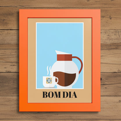 A framed art print with a bright orange frame and a beige mat, featuring a minimalist illustration of a white coffee mug and a white coffee carafe with brown coffee against a light blue background. The text 'BOM DIA' is printed in black at the bottom.
