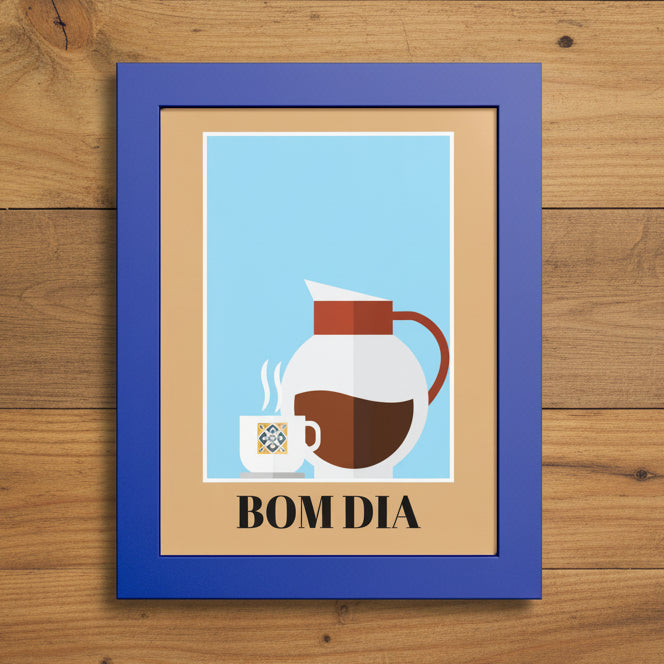 A framed art print with a blue frame and tan mat, featuring a minimalist illustration of a white coffee mug and a white coffee carafe with brown coffee against a light blue background, with the text 'BOM DIA' printed below.