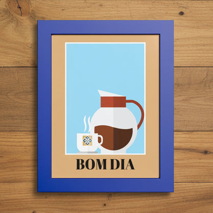 A framed art print with a blue frame and tan mat, featuring a minimalist illustration of a white coffee mug and a white coffee carafe with brown coffee against a light blue background, with the text 'BOM DIA' printed below.