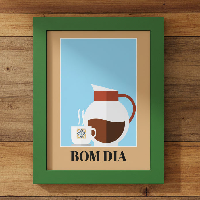 A framed art print with a green frame and beige mat, featuring a minimalist illustration of a white coffee mug and a white coffee pot with brown coffee against a light blue background, with the text 'BOM DIA' printed below.