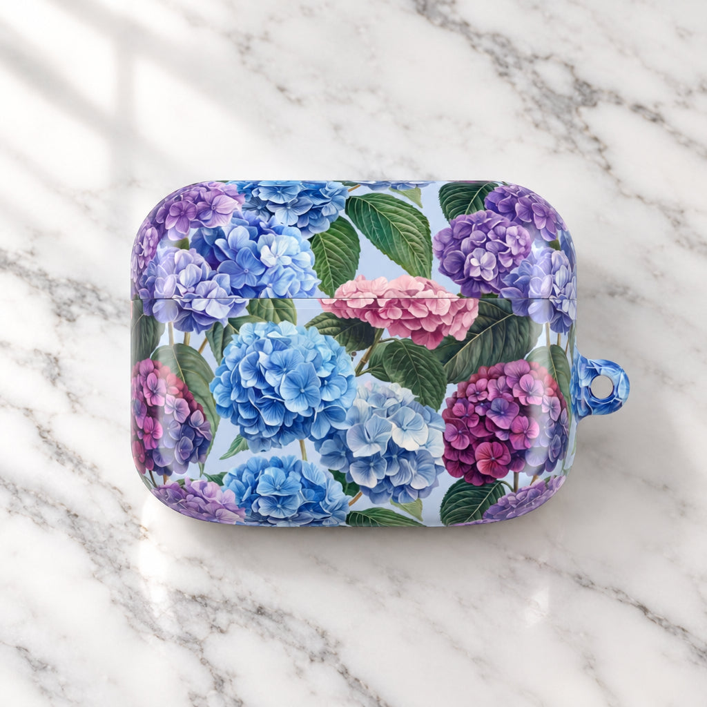 A protective phone case featuring a detailed watercolor-style print of blue, purple, and pink hydrangeas with green leaves on a light background, complete with a translucent blue loop at the top right.
