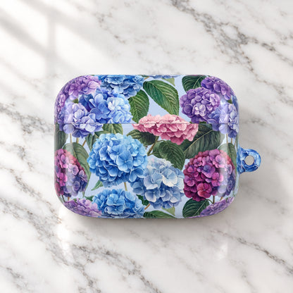 A protective phone case featuring a detailed watercolor-style print of blue, purple, and pink hydrangeas with green leaves on a light background, complete with a translucent blue loop at the top right.