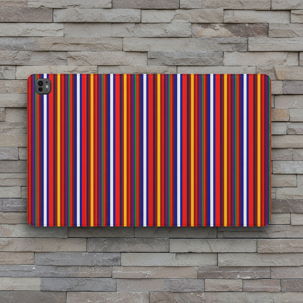 A protective tablet case featuring a vibrant, dense pattern of vertical stripes in red, orange, yellow, blue, purple, and white, shown on a stone wall