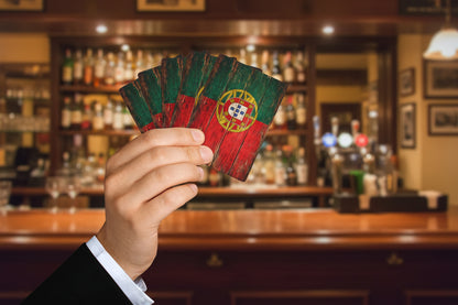 Hand holding a set of playing cards with a Portuguese flag design on a white background